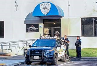 Image of the friend of the Tulalip Tribal Police administration building with two officers and a patrol vehicle