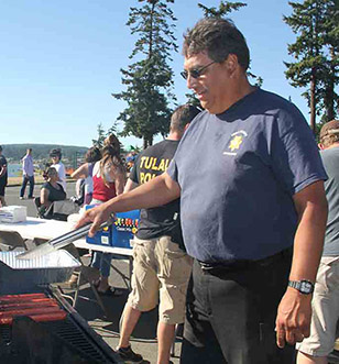 Tulalip Tribal Police Department officers in the community, serving up barbecued meals.