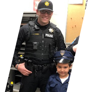 Tulalip Tribal Police Department officer with young child in police uniform. header sliding image.